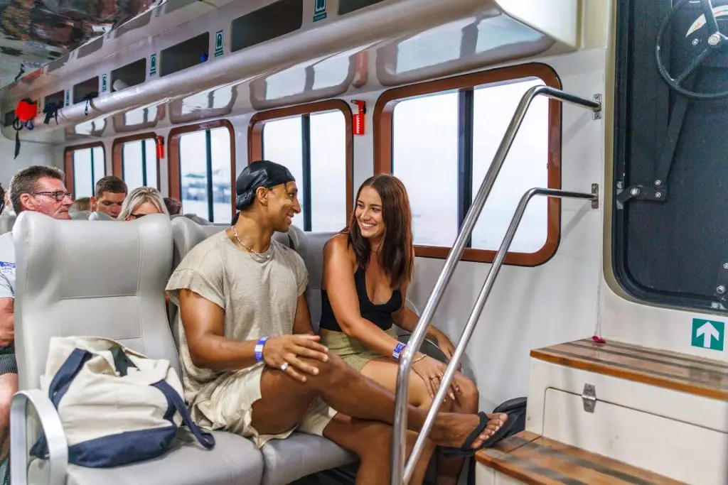 Couple seated in the Setia Fast Ferry cabin, smiling and enjoying their trip.